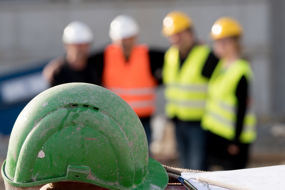 construction workers blurred behind a hardhat